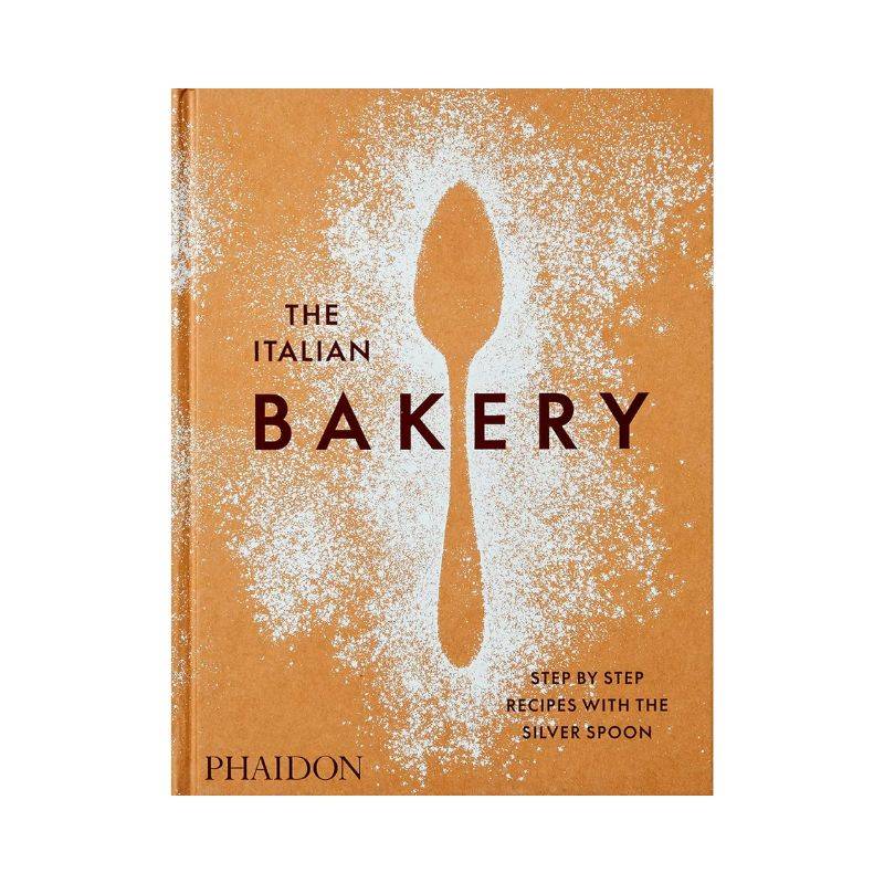 Livro The Italian Bakery Phaidon Press com capa dura sobre mesa de centro em cozinha iluminada com utensílios de cobre e ramo