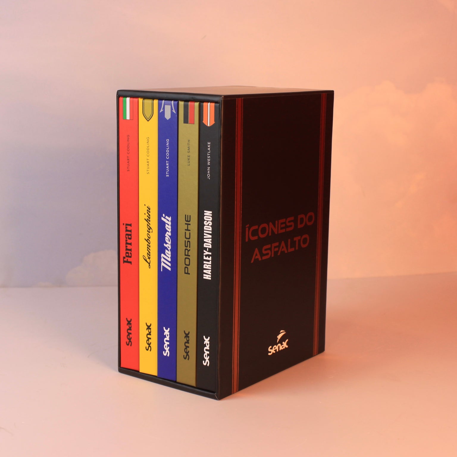 Livro Coleção Ícones do Asfalto com capa dura sobre mesa de centro de madeira escura, ao lado de uma miniatura de carro cláss