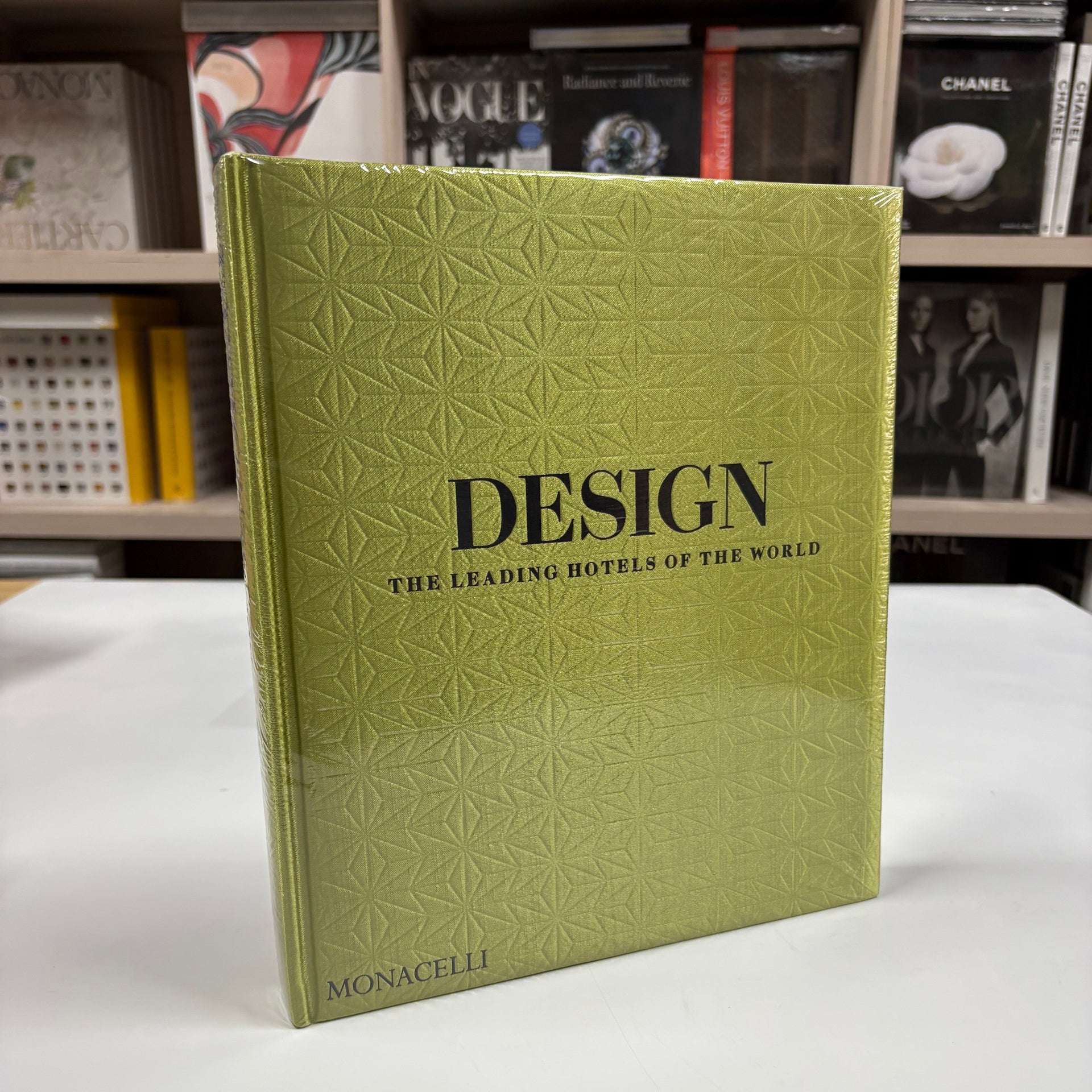 Livro Design: The Leading Hotels of the World com capa dura exibido sobre mesa de centro em ambiente elegante, com decoração