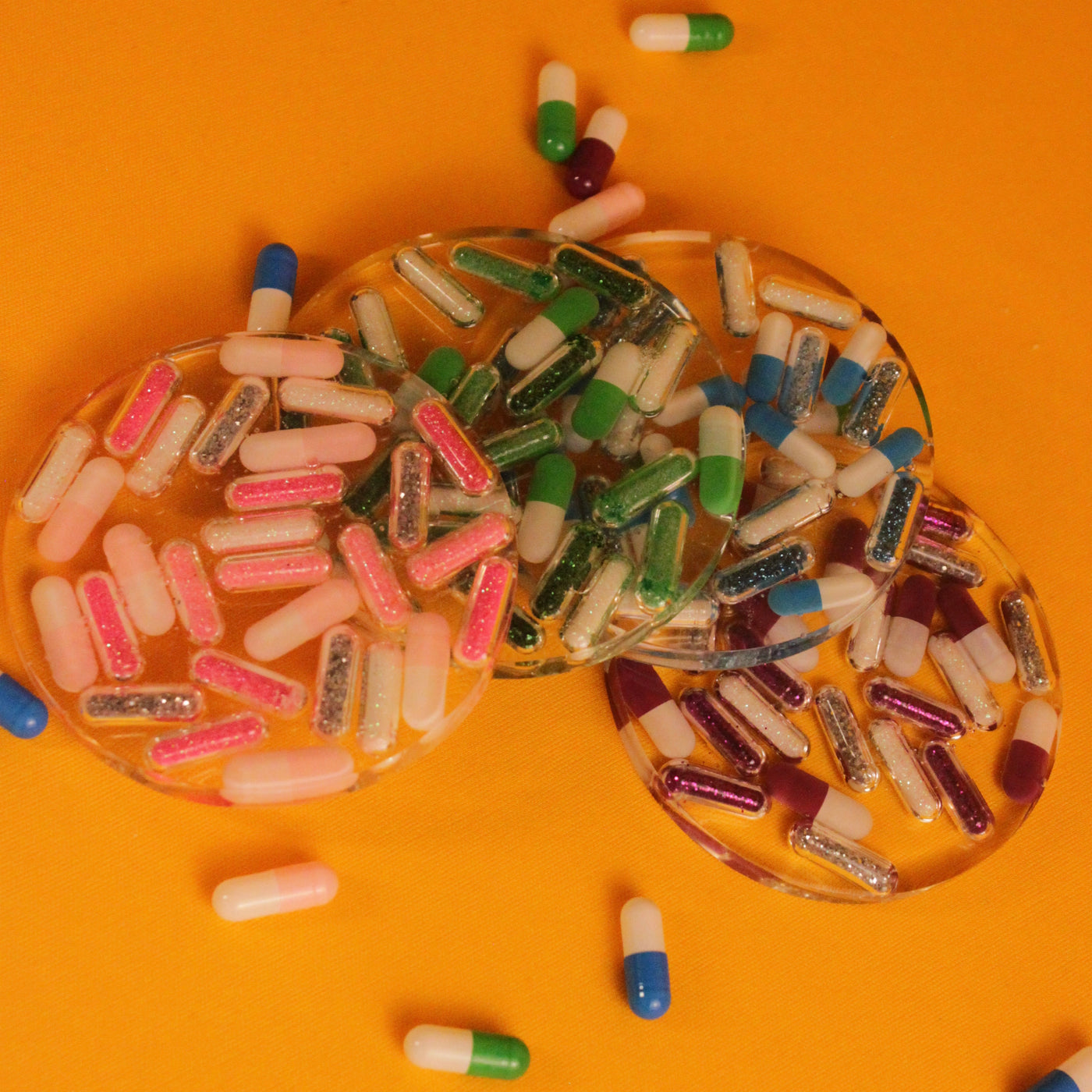 Kit de porta-copos Daily Dose em resina colorida, formato de pílula, com 4 unidades nas cores azul, rosa, roxo e verde