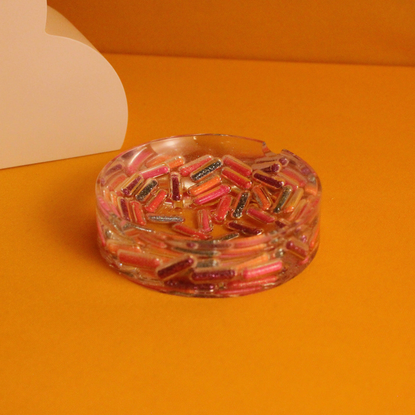 Cinzeiro decorativo Hot Dose em resina pigmentada com cápsulas coloridas, peça de design para mesa e bar em casa