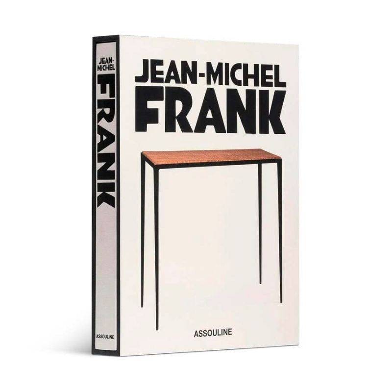 Livro Jean-Michel Frank da Assouline com capa dura sóbria sobre mesa de centro de madeira nobre em sala de estar minimalista