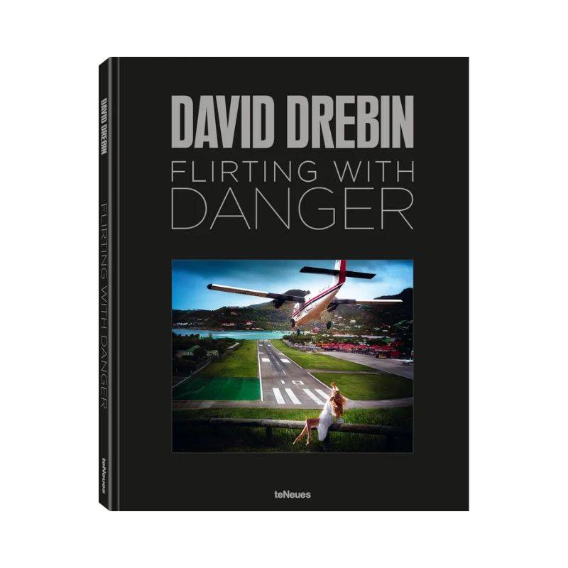 Livro Flirting with Danger de David Drebin aberto sobre mesa de centro de madeira escura, revelando fotografia artística em p
