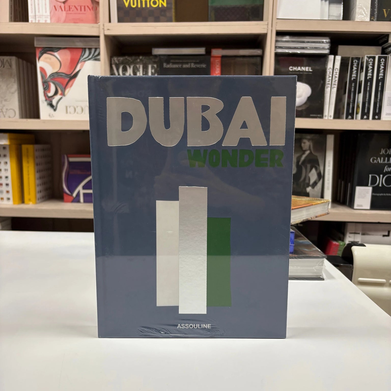 Livro Dubai Wonder Assouline com capa dura sobre mesa de centro de mármore em ambiente sofisticado com vista para a cidade